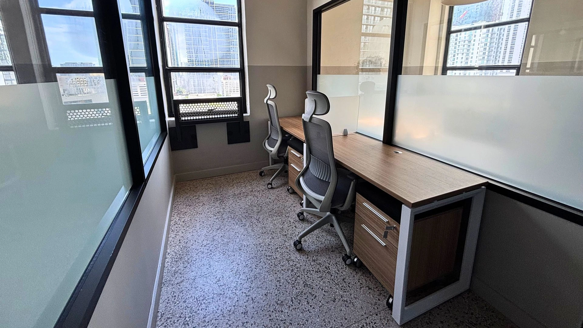 Private office with a wood desk, a grey task chair and a storage pedestal by the window