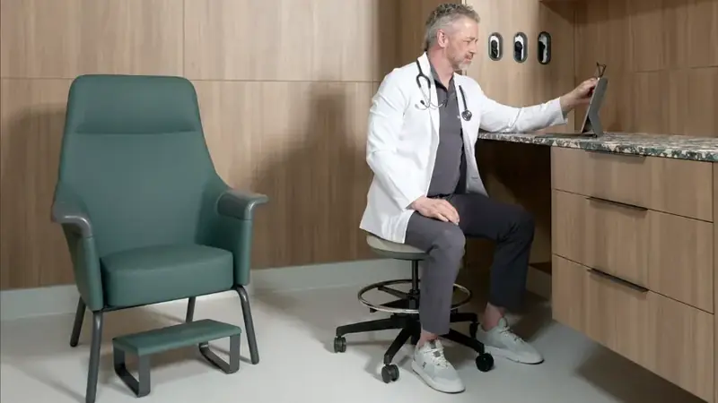 Medical exam room with a patient chair, footrest, doctor's stool and built-in counter