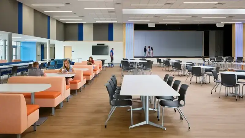 School commons with booth seating, long tables and stacking chairs